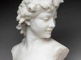 a white marble bust of a woman with flowers on her head