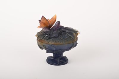 un petit vase surmonté d'un papillon
