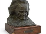 a bronze bust of a woman on a wooden base