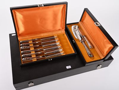 un coffret noir contenant un service d'argenterie