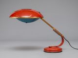 an image of a red and blue desk lamp on a white surface