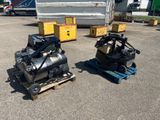 two air compressors sitting on pallets in a parking lot