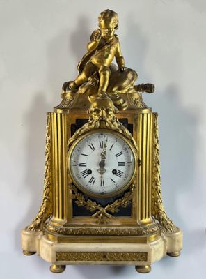 a gold clock with a statue on top of it