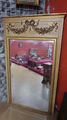 un miroir posé sur le sol devant un mur rouge