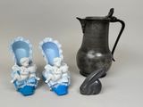 trois figurines miniatures représentant des bébés chaussés de chaussures bleues et un pichet argenté