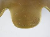 a close up of a gold vase on a white surface
