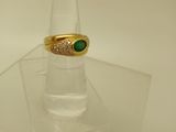 une bague en or surmontée d'une pierre verte