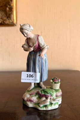 a figurine of a woman with a basket of flowers on a table