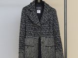 a black and white jacket hanging on a hanger in a room
