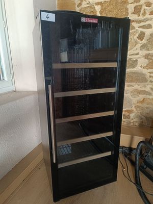 a wine cooler that is sitting on the floor next to a window