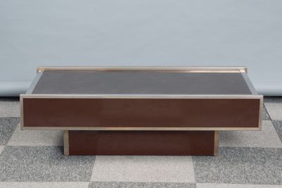 une table basse au plateau marron posée sur un sol à carreaux