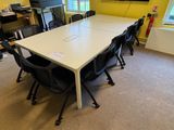 tables and chairs in a room with a flat screen tv on the wall