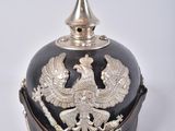 un casque noir et argent orné d'un oiseau