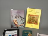 several books on display on a table in front of a gray wall