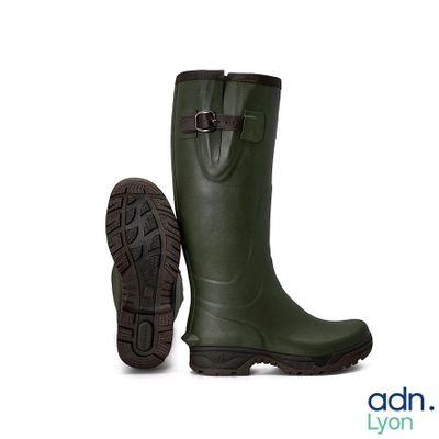 des bottes en caoutchouc vertes avec des boucles et des semelles en caoutchouc, sur fond blanc