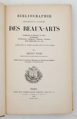 un livre ouvert posé sur une table à côté d'un mur blanc