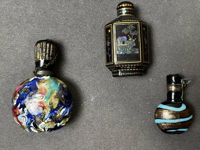 trois flacons de parfum posés les uns à côté des autres
