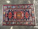 a colorful rug on a concrete floor with a wall in the background