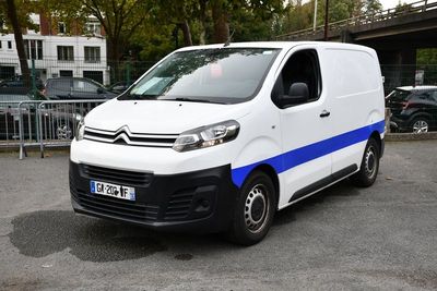 a white van with blue stripes parked in a parking lot