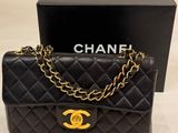 a chanel black quilted bag with gold hardware
