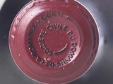 a close up of a wine bottle with a red lid