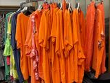 beaucoup de vêtements suspendus à une étagère dans une pièce