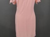 a pink dress on a mannequin stand against a gray background