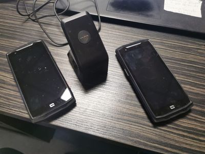 three cell phones sitting on a table next to a laptop