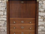 an image of a wooden cabinet with a marble top on a stone floor