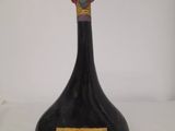 a black bottle with a red cap on top of it
