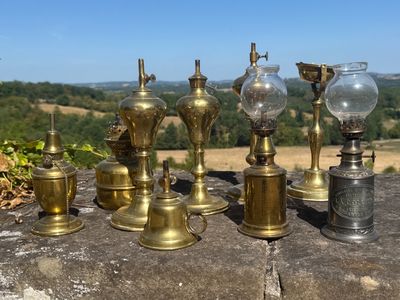 de nombreux modèles de lampes en laiton posées sur un rebord en pierre