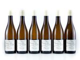 six bottles of wine are lined up on a white surface