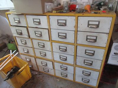 yellow and white filing cabinet with lots of drawers in a room