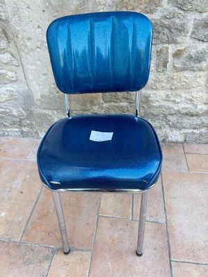 une chaise bleue posée sur un sol carrelé