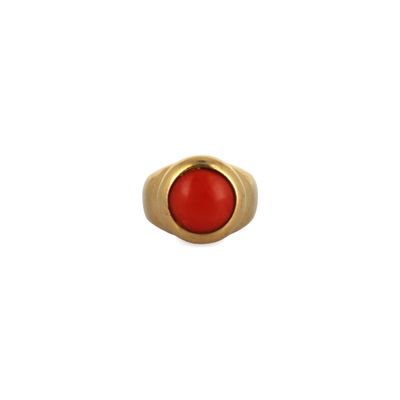 a close up of a gold ring with a red stone