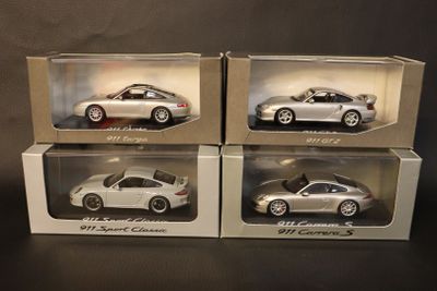 three boxed boxes of silver model cars on a black surface