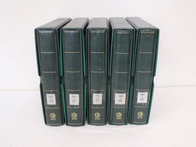 six livres verts sont alignés sur une surface blanche