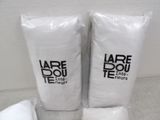 two bags of white toilet paper sitting on the floor