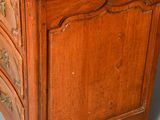a small wooden chest of drawers on a grey floor
