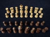 many pieces of chess on a black surface