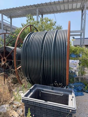 a large black hose that is next to a trash can