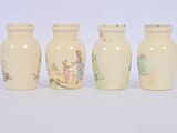 four small vases sitting next to each other on a white surface