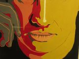 un tableau représentant le visage d'une femme, exposé dans une vitrine