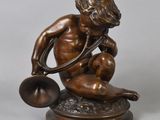 bronze statue of a boy with a bell on a marble base