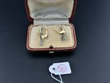 une paire de boucles d'oreilles dans une boîte avec une étiquette de prix