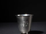 an old silver cup sitting on top of a black table
