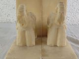 two figurines of people sitting on top of each other