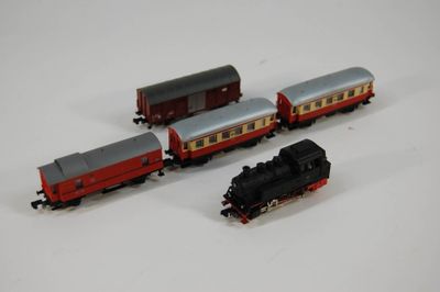 trois petits trains sur une surface blanche ; l'un est rouge et l'autre est noir