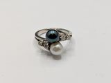 a close up of a ring with a pearl and a diamond