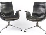 pair of black leather chairs on castors with metal legs